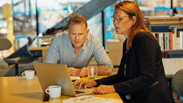 Mand og kvinde snakker sammen over computeren